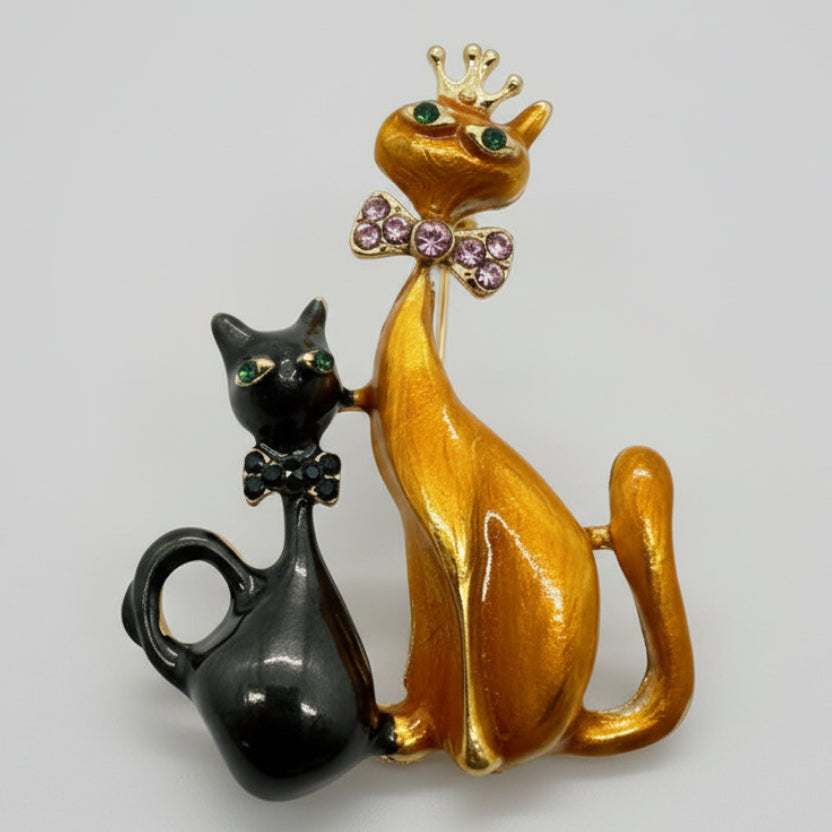 Black and orange cat sisters brooch on a light gray background