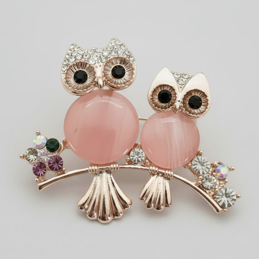 Pink moonstone owl pair brooch on a light gray background