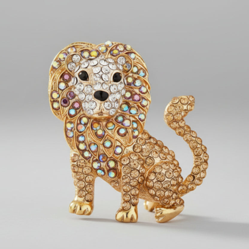 Golden rhinestone lion brooch on a light gray background